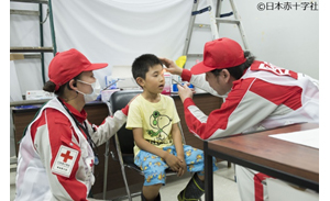 平成30年北海道胆振東部地震での救護活動で子供の手当てをする日赤の医療チーム